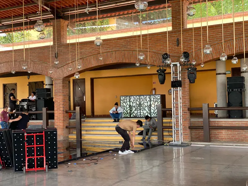 Equipo montando audio, iluminación y cabina antes del evento